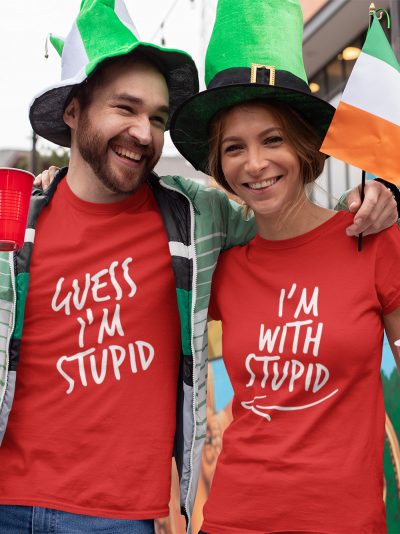 man and woman standing close and smiling wearing I am with stupid Red Couple T-shirt